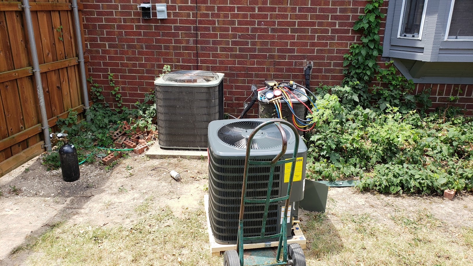 D&E technician servicing an AC condenser
